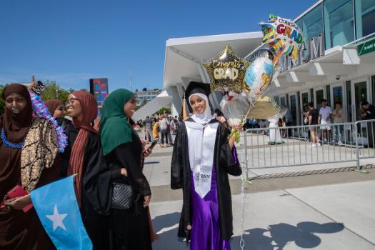 Graduates outside of Climate Pledge Arena holding balloons