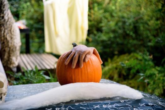 a hand over a pumpkin